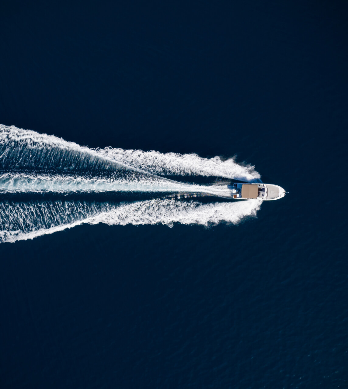 Boat Cutting Through Blue Sea (Top View)